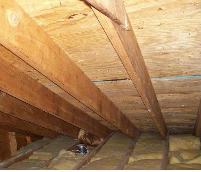 an attic space with yellow insulation