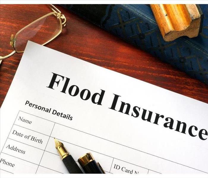 Flood insurance form on a table with a book
